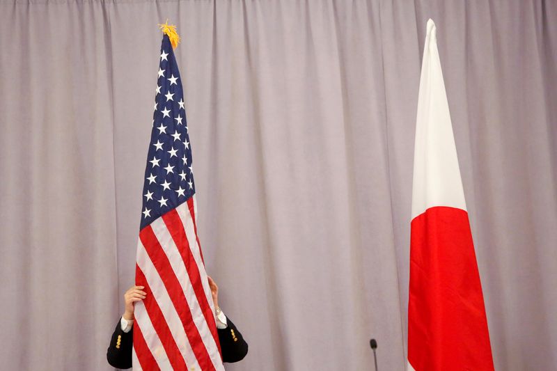 A worker adjusts the U.S. flag before Japanese Prime Minister