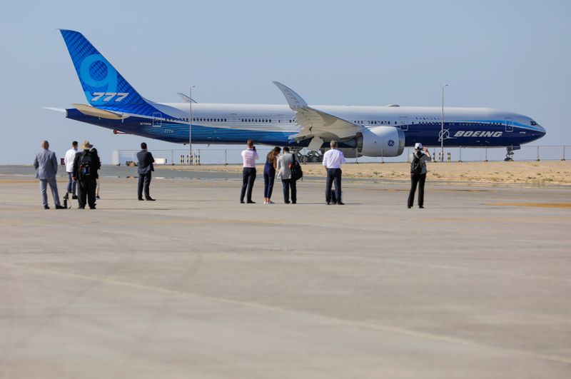 Visitors stand in front of the plane Boeing 777X during