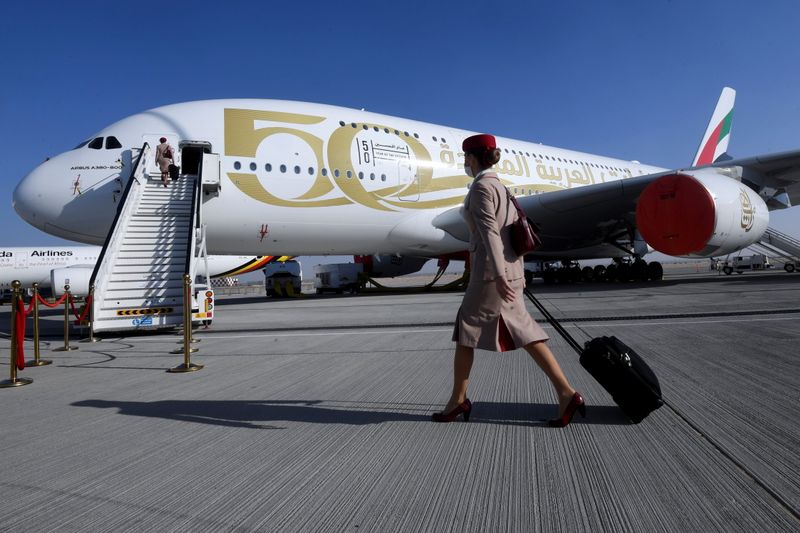 Emirates airline crew member walks past plane during Dubai Air