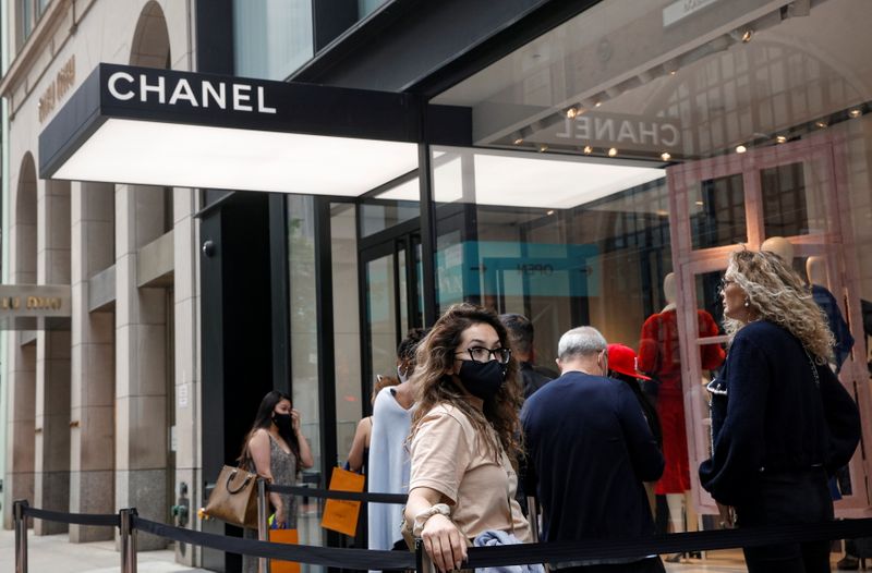 FILE PHOTO: Shoppers wait in line to enter the Chanel