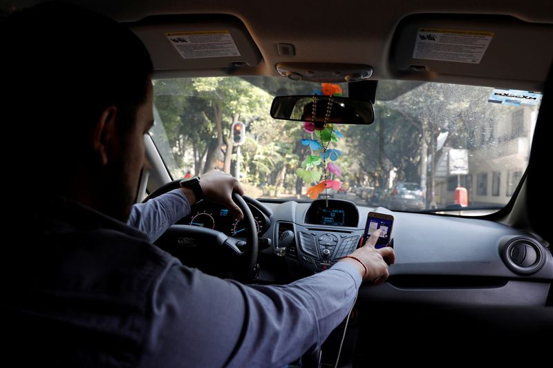 FILE PHOTO: Uber driver checks the route on a mobile