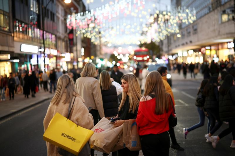 FILE PHOTO: People walk along Oxford Street illuminated with Christmas