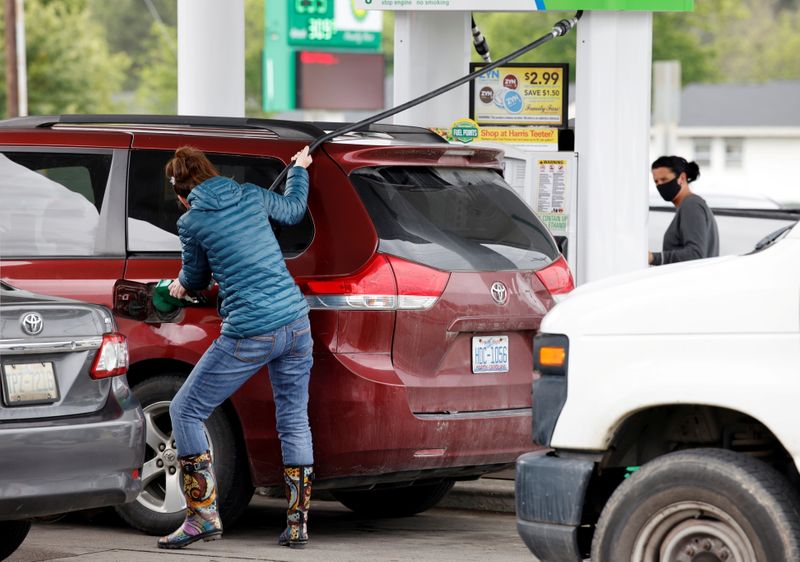 FILE PHOTO: Motorist stretches fuel hose as gasoline station during