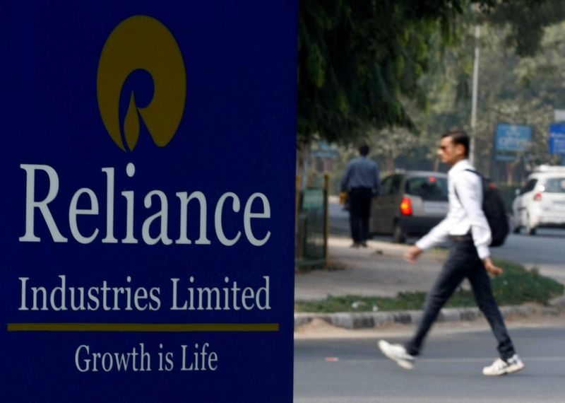 FILE PHOTO: A man walks past a Reliance Industries Limited