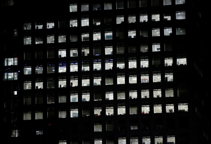 FILE PHOTO: Office lighting is seen through windows of a
