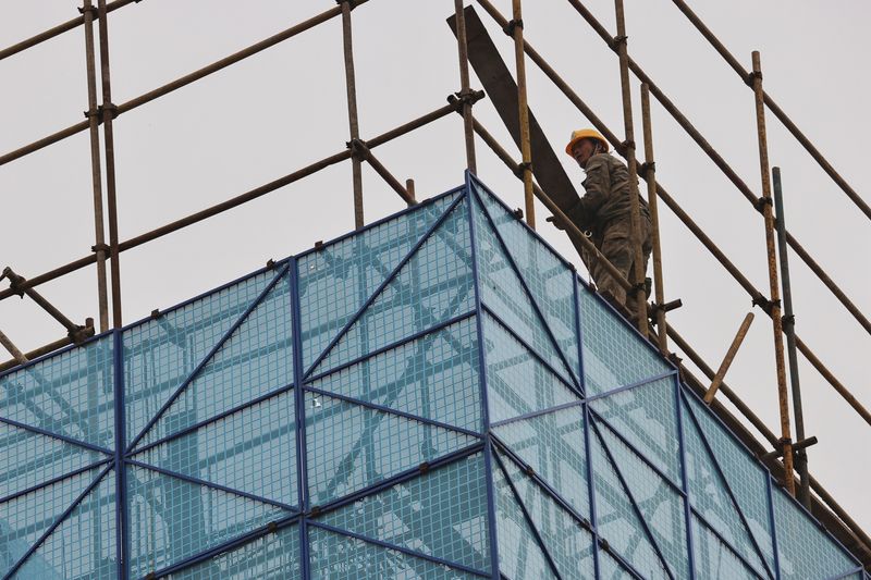 FILE PHOTO: A man walks on a scaffolding at the