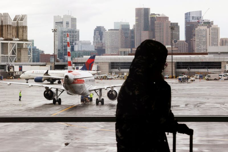 Passengers travel through Logan Airport in Boston