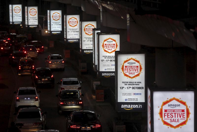 Traffic moves on a road past advertisements of Indian online