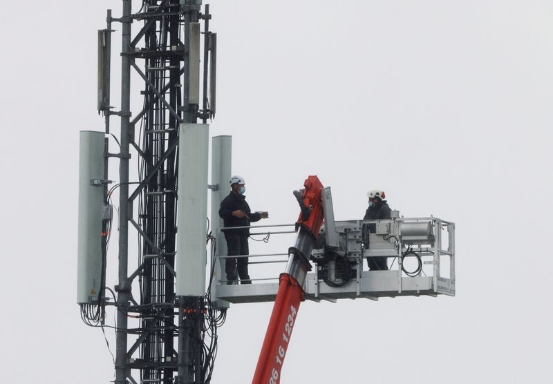 FILE PHOTO: Technicians work at the top of transmitting antennas