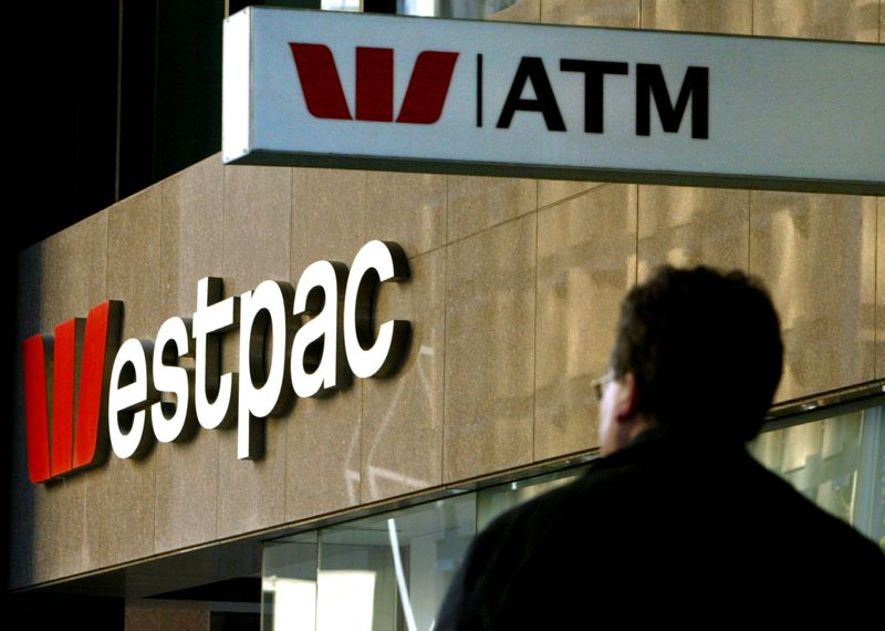 FILE PHOTO: A pedestrian passes below signs for Westpac Bank