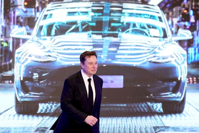 FILE PHOTO: Tesla Inc CEO Elon Musk walks next to