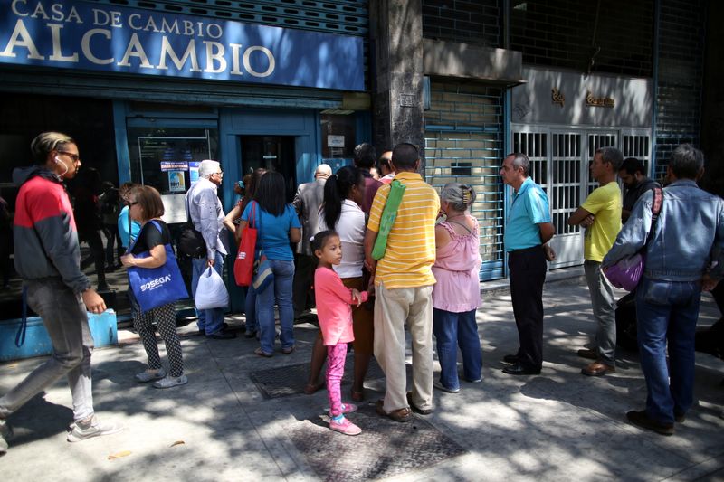 FILE PHOTO: People wait in line outside of a currency