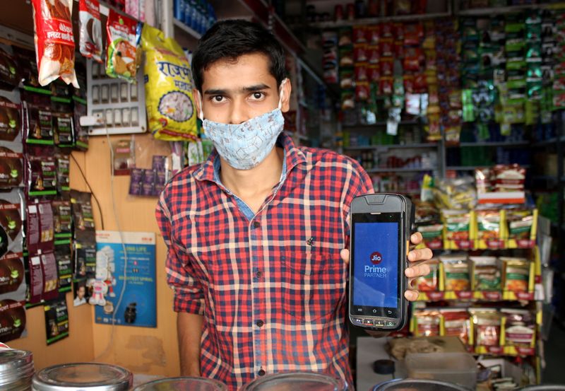 FILE PHOTO: A shopkeeper selling consumer goods displays Reliance’s JioMart