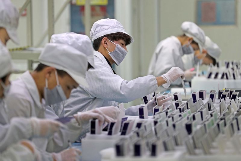 Workers are seen at a production line manufacturing solar photovoltaic