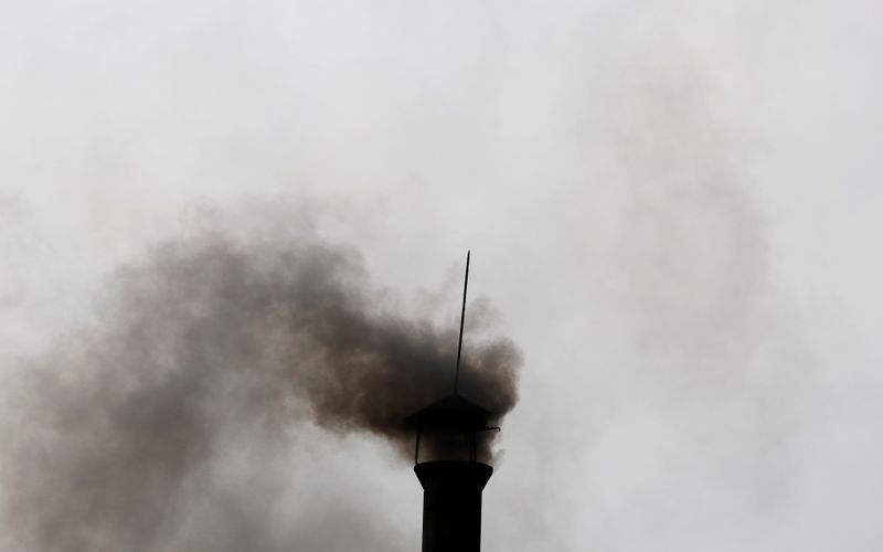 Smoke rises from the chimney of a paper factory outside