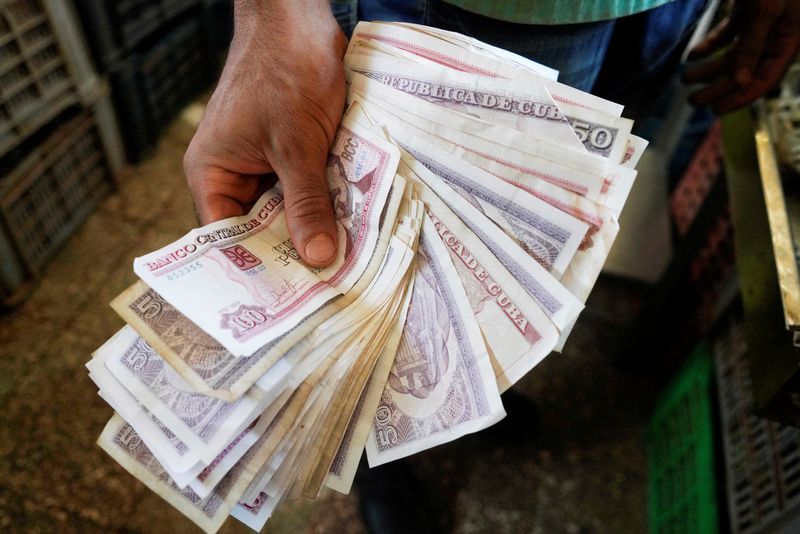 FILE PHOTO: A vendor shows Cuban pesos notes in a