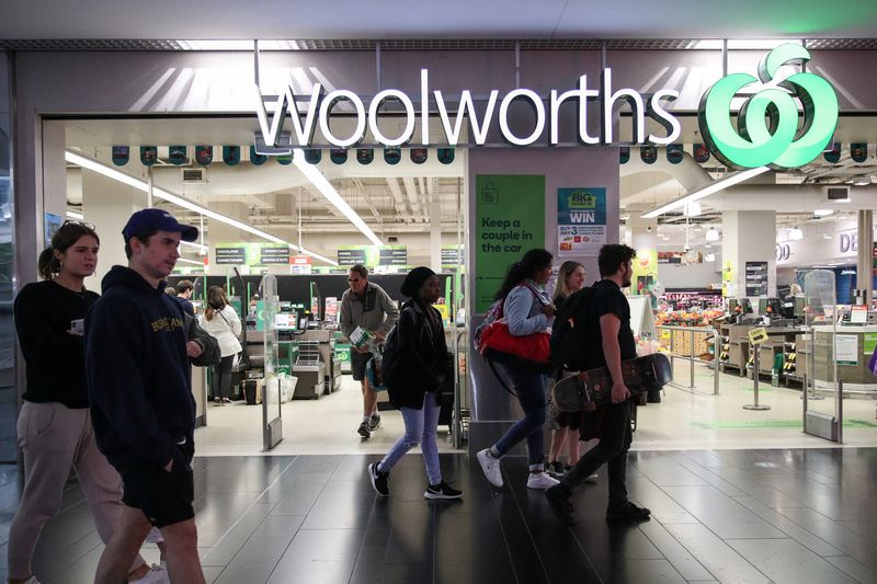 People walk past a Woolworths supermarket in Sydney