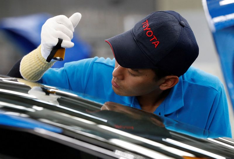 FILE PHOTO: Employees of Toyota Motor Corp. work on assembly