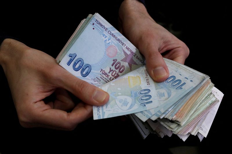FILE PHOTO: A merchant counts Turkish lira banknotes at the