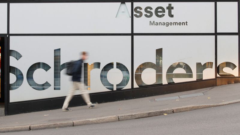 A man walks past the logo of investment management company