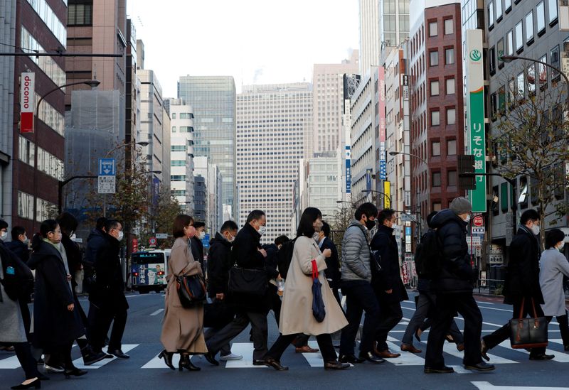 FILE PHOTO: Pedestrians wearing protective masks, following the coronavirus disease