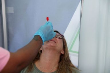 FILE PHOTO: Healthcare worker collects a swab from Bronwen Cook