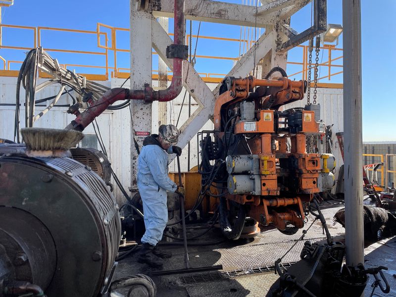 A rig hand works on an electric drilling rig for