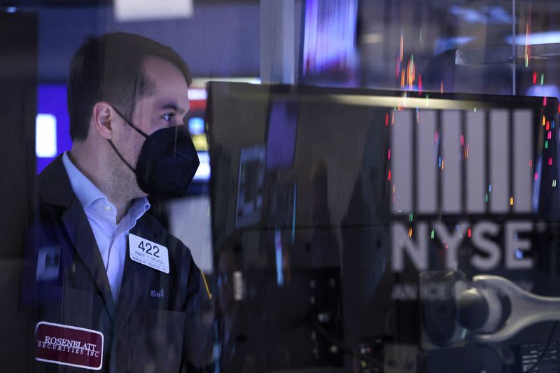 A trader in a face mask works on the trading