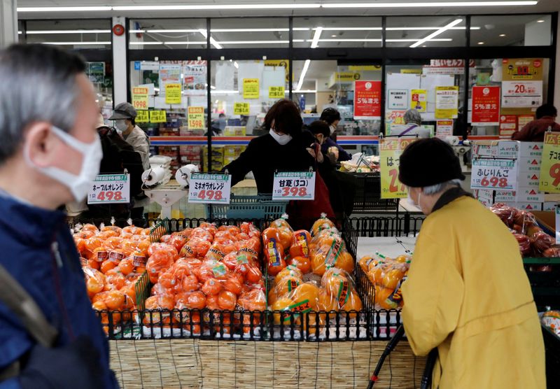 FILE PHOTO: Shoppers wearing protective face masks, following an outbreak