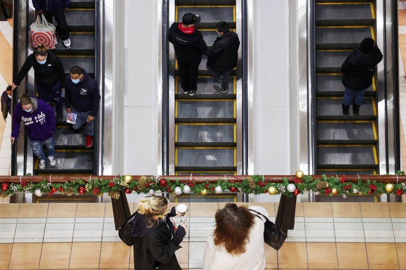 People ride an escalator while others stand at a mall