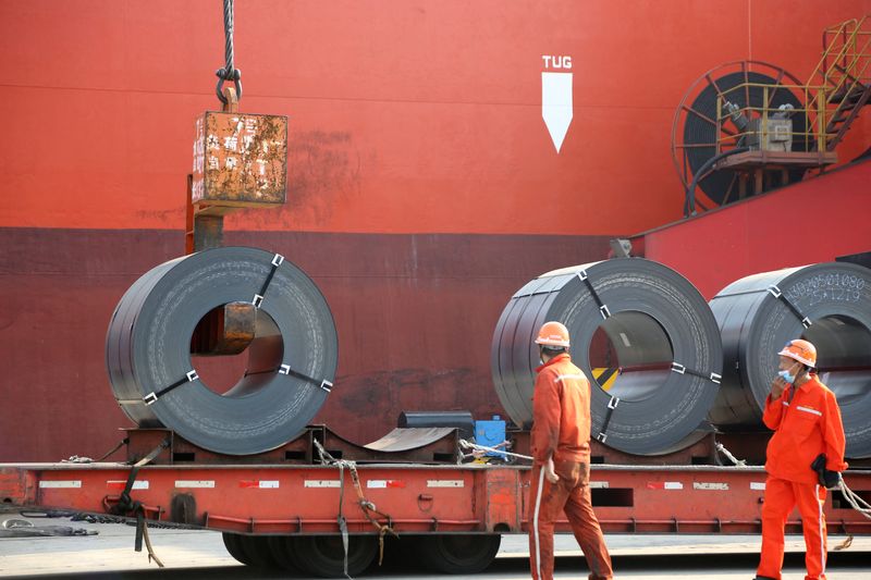 Workers load steel products for export to a cargo ship