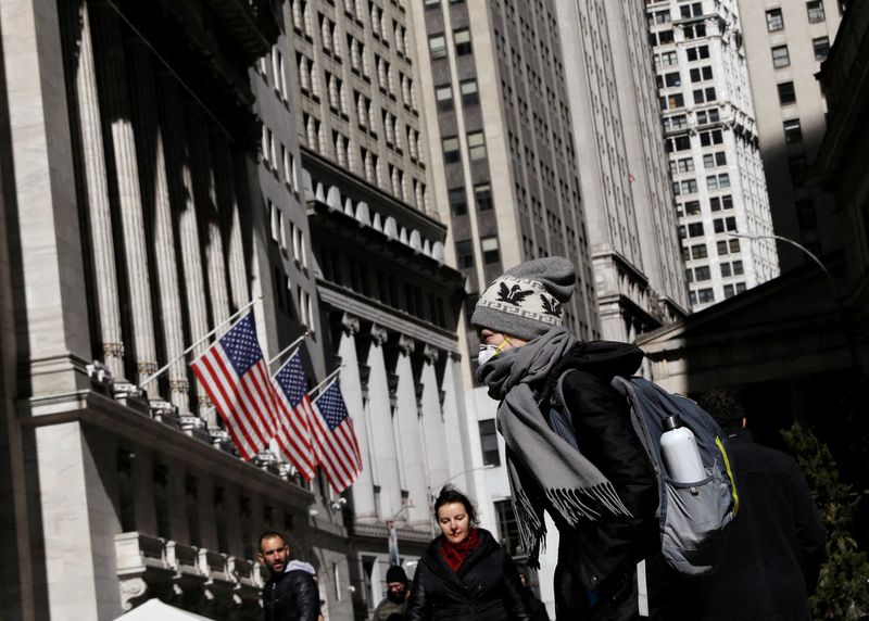 FILE PHOTO: A woman wears a mask near the NYSE