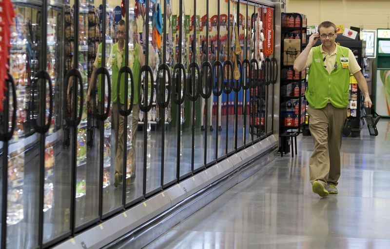 FILE PHOTO: A Wal-Mart employee is reflected in the cold