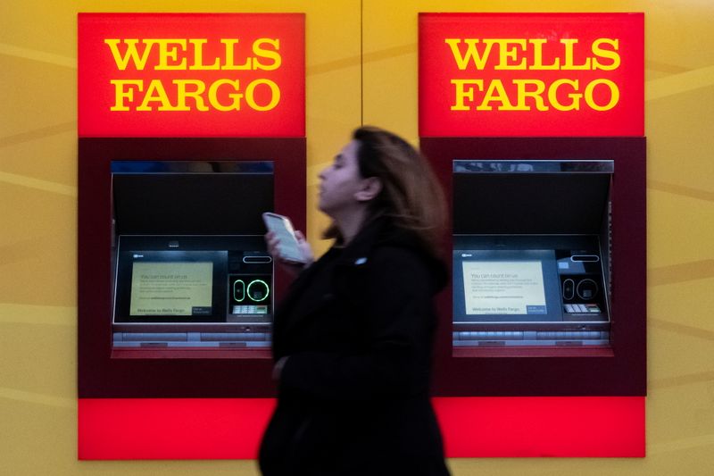 FILE PHOTO: A woman walks past Wells Fargo bank in