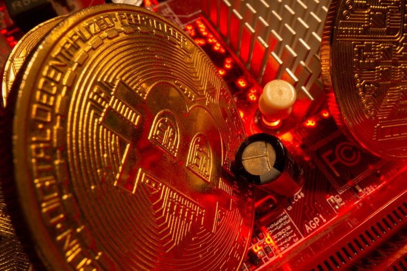 Representations of the virtual currency Bitcoin stand on a motherboard