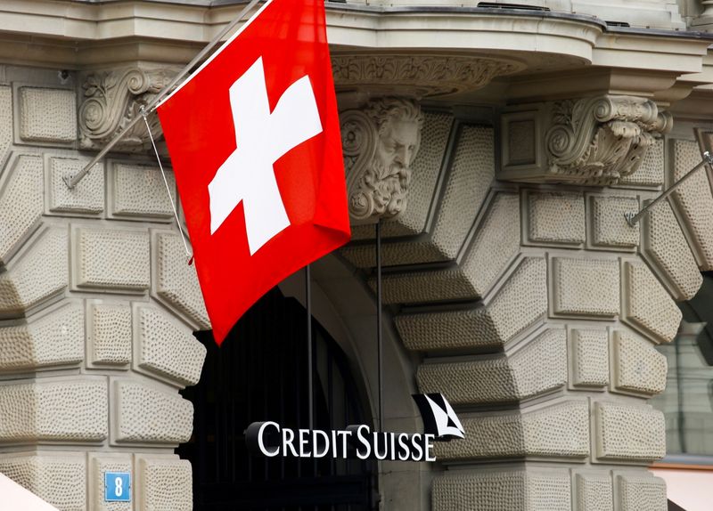 FILE PHOTO: Switzerland’s national flag flies above the logo of