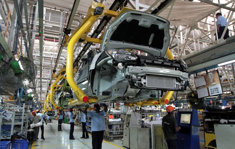 Workers assemble Ford cars at a plant of Ford India