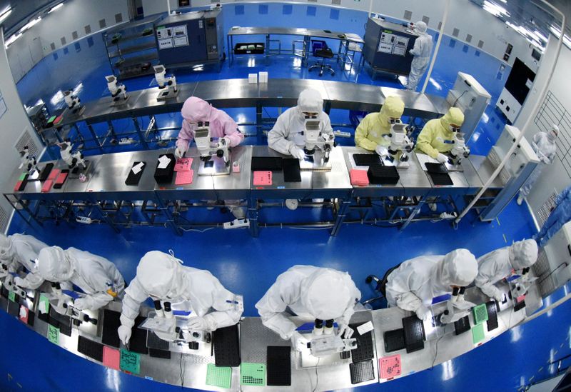 FILE PHOTO: Employees work on a production line manufacturing camera