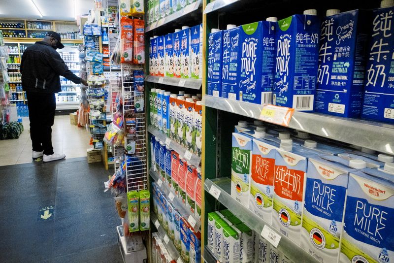 Cartons of milk are displayed on shelves at a supermarket