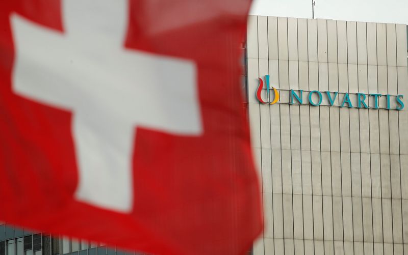 Switzerland’s national flag flies in front of the logo of