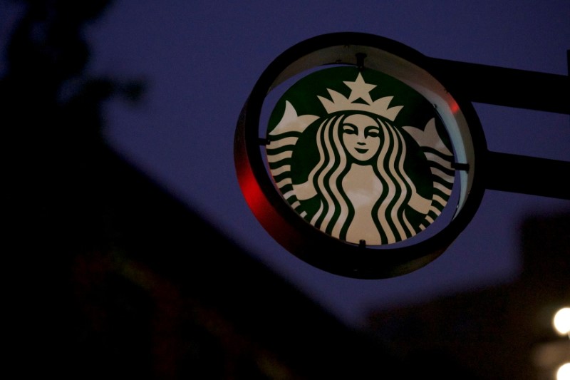 FILE PHOTO: Traffic lights illuminate a Starbucks sign before the