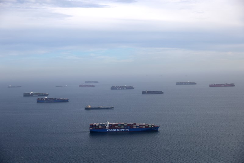 Container ships and oil tankers wait in the ocean outside