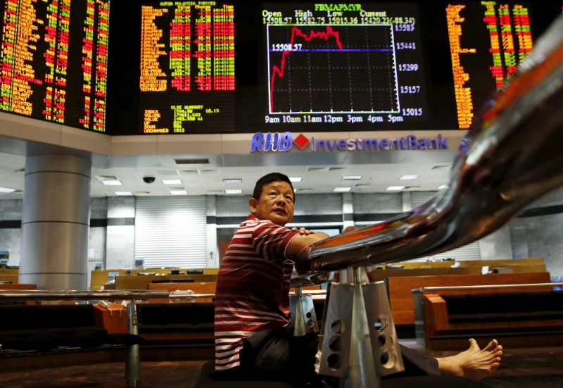 FILE PHOTO: An investor monitors share market prices in Kuala