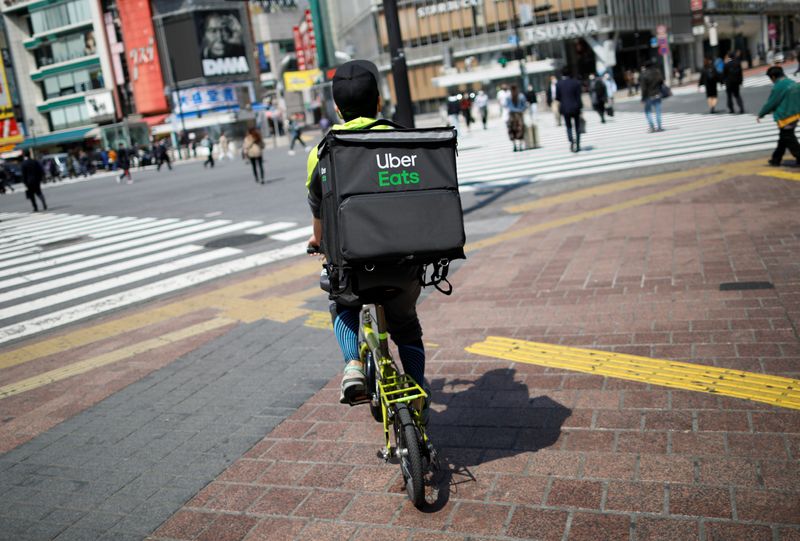 An Uber Eats delivery person rides a bicycle during an