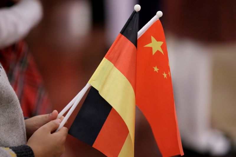 FILE PHOTO: A student holds flags of China and Germany