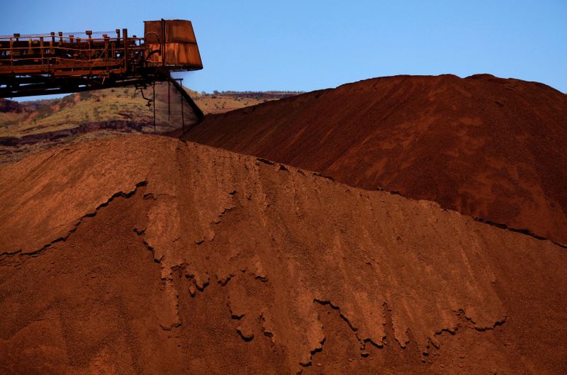 FILE PHOTO: A stacker unloads iron ore onto a pile