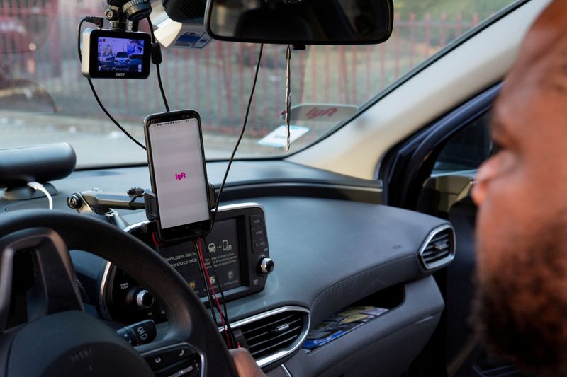 FILE PHOTO: Uber and Lyft driver Adama Fofana sits in