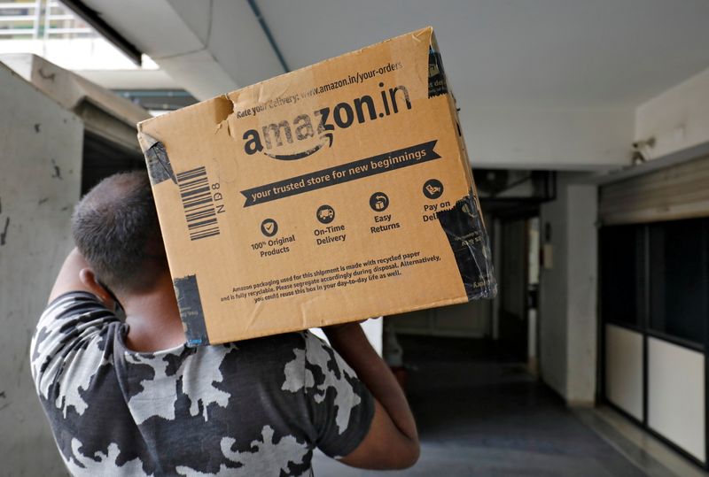 FILE PHOTO: A delivery worker carries an Amazon package in