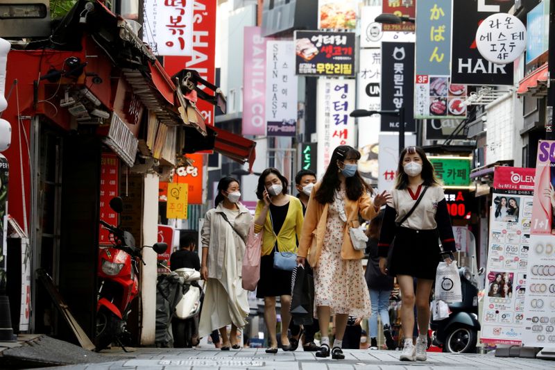 FILE PHOTO: People wearing masks walk at Myeongdong shopping district