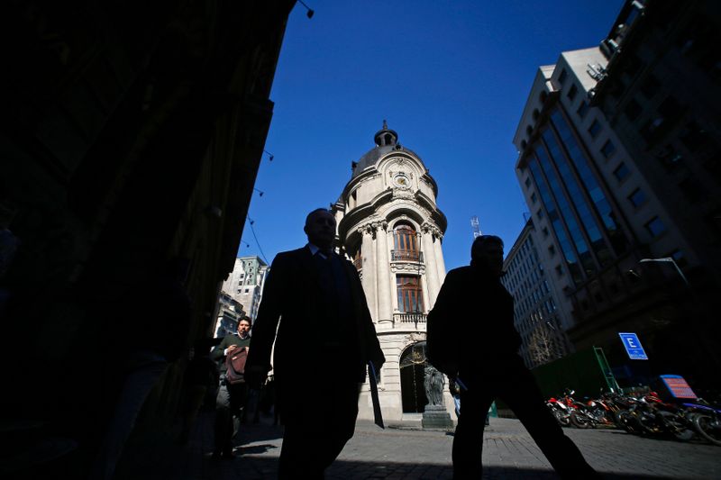 Men walk through the financial district next to Santiago’s stock
